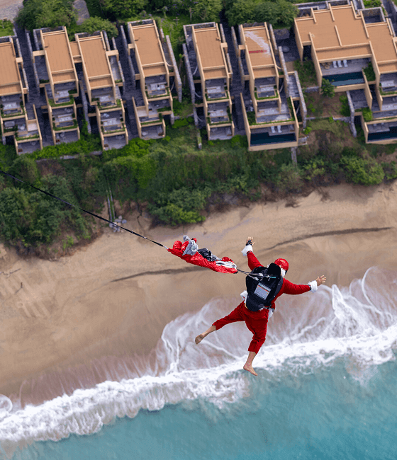 A birds-eye view of Santa Claus skydiving onto the beach.