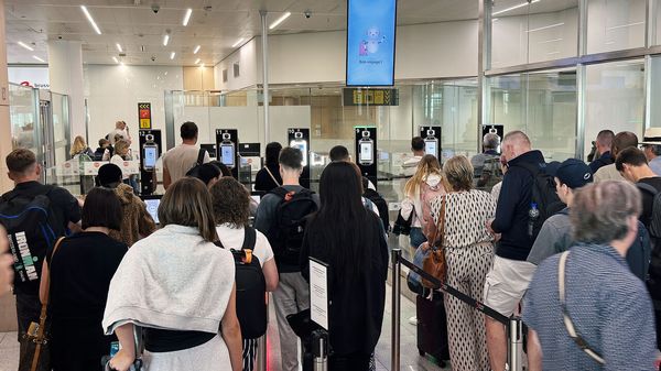 Passengers wait in long queues at passport control in the departures terminal of Brussels Airport.