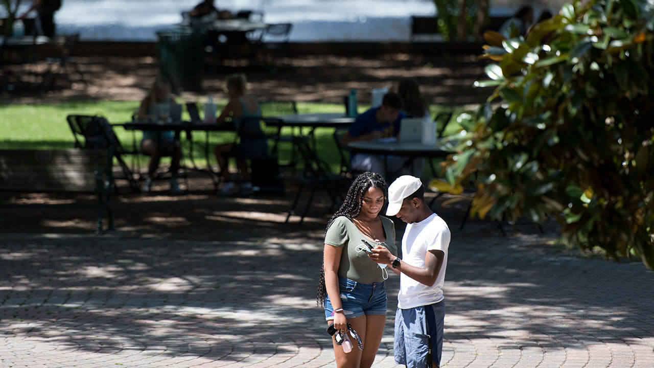 Students look at a smart phone on campus at the University of South Carolina