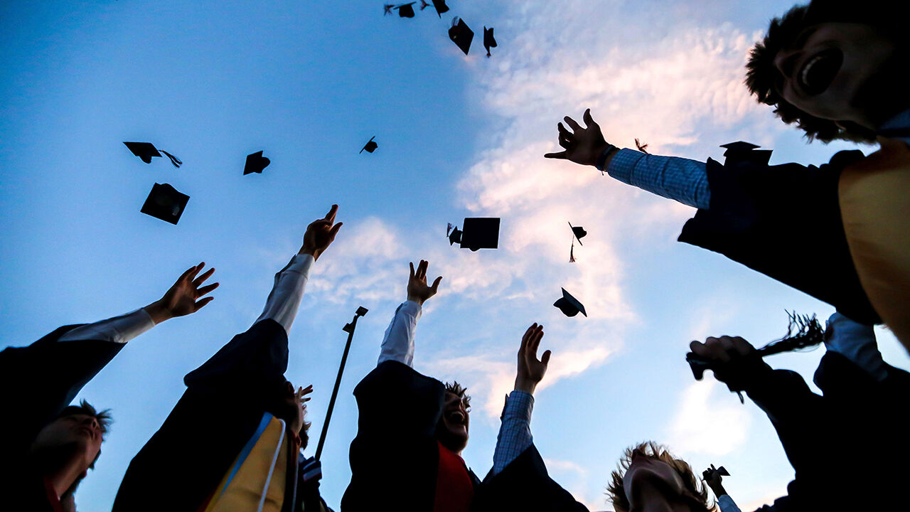 A students throw their caps into the sky at the Tupelo Christian Preparatory School graduation ceremony at Hope Church