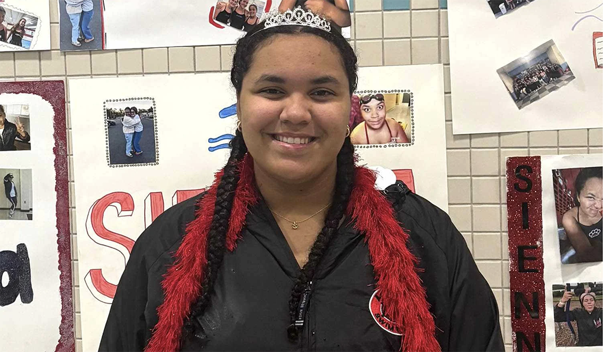 A young woman wearing a crown and smiling.