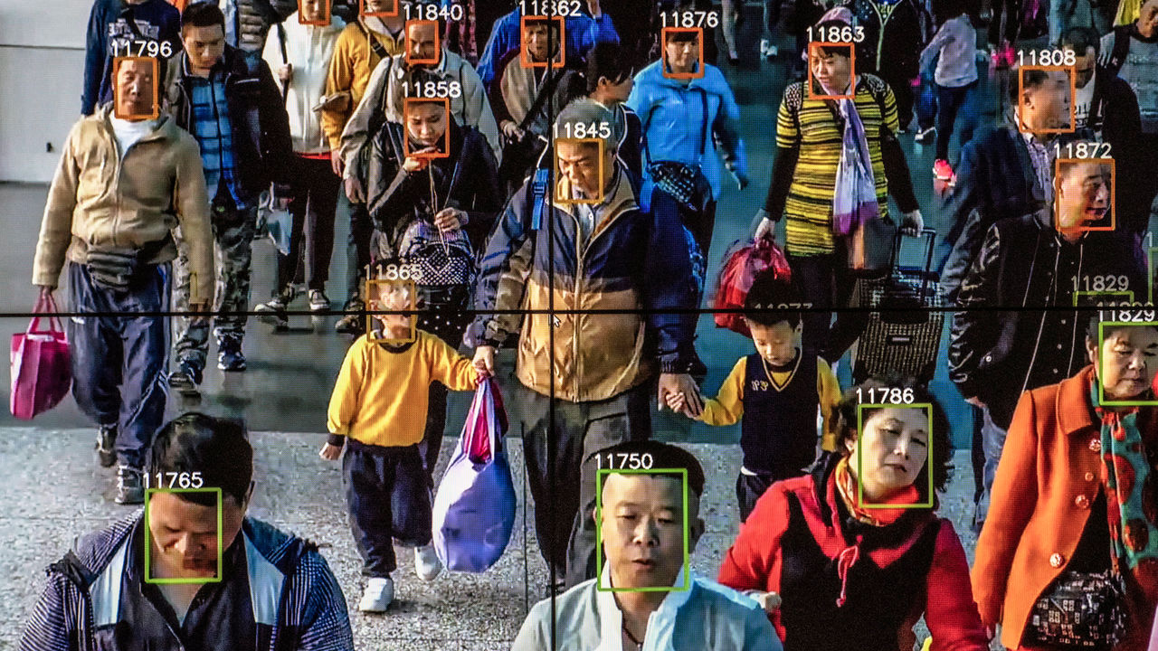 A monitor displays video showing facial recognition software in use.