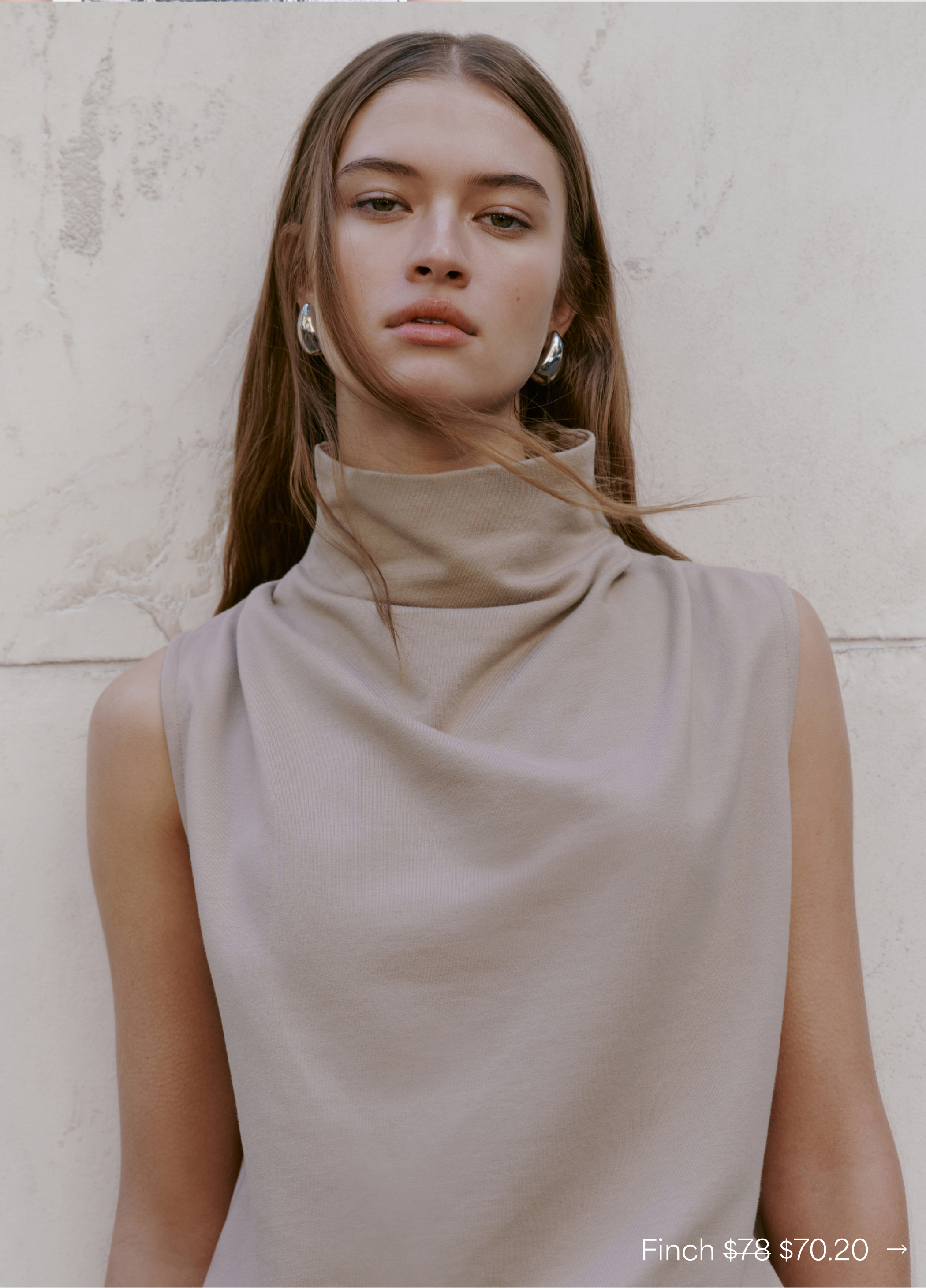 Close-up of Bianca in The Finch Top with sculptural draping and silver hoop earrings.