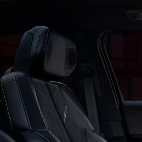 Interior of the 2026 LYRIQ-V highlighting the premium seating with exclusive V-Series badging and speakers in the headrest.
