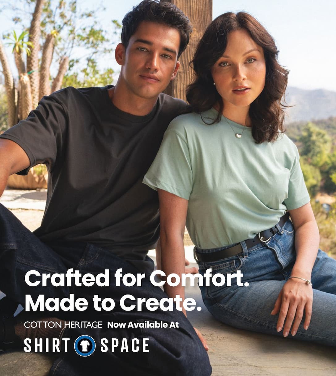 A young couple wearing Cotton Heritage t-shirt with the text overlay "Crafted for Comfort. Made to Create. Cotton Heritage Now Available At ShirtSpace."" 
