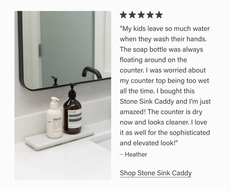 White stone sink caddy holding soap dispensers on a bathroom counter near a mirror. Five-star review reads: “My kids leave so much water… The counter is dry now and looks cleaner.” – Heather. Text link: “Shop Stone Sink Caddy.”