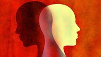 Illustration of a black head and white head back to back on a red background