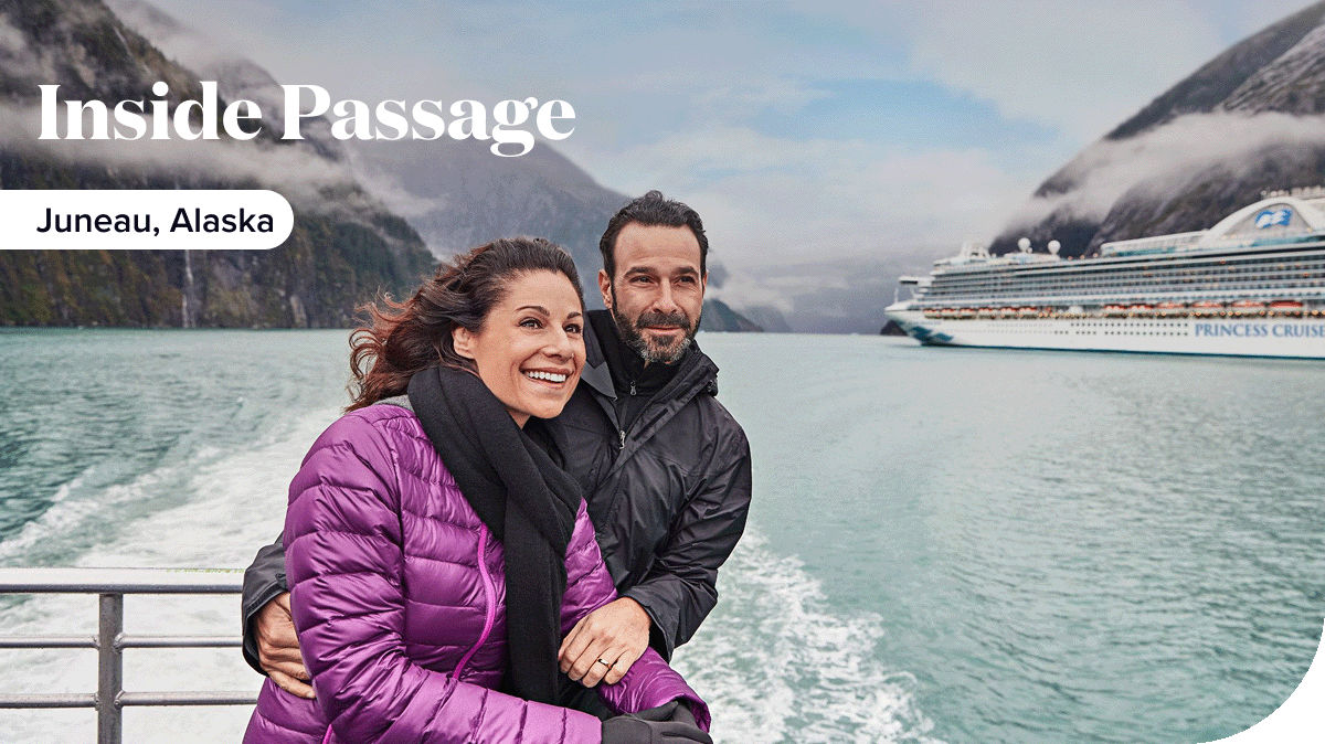 A couple looks out at Juneau, Alaska from the deck of a Princess ship.
