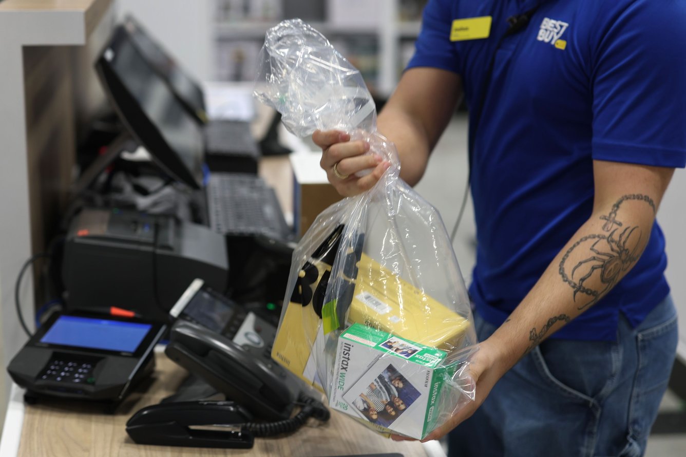 Best Buy sales advisor, packages up a customers purchase at Best Buy on December 23, 2025 in Miami, Florida