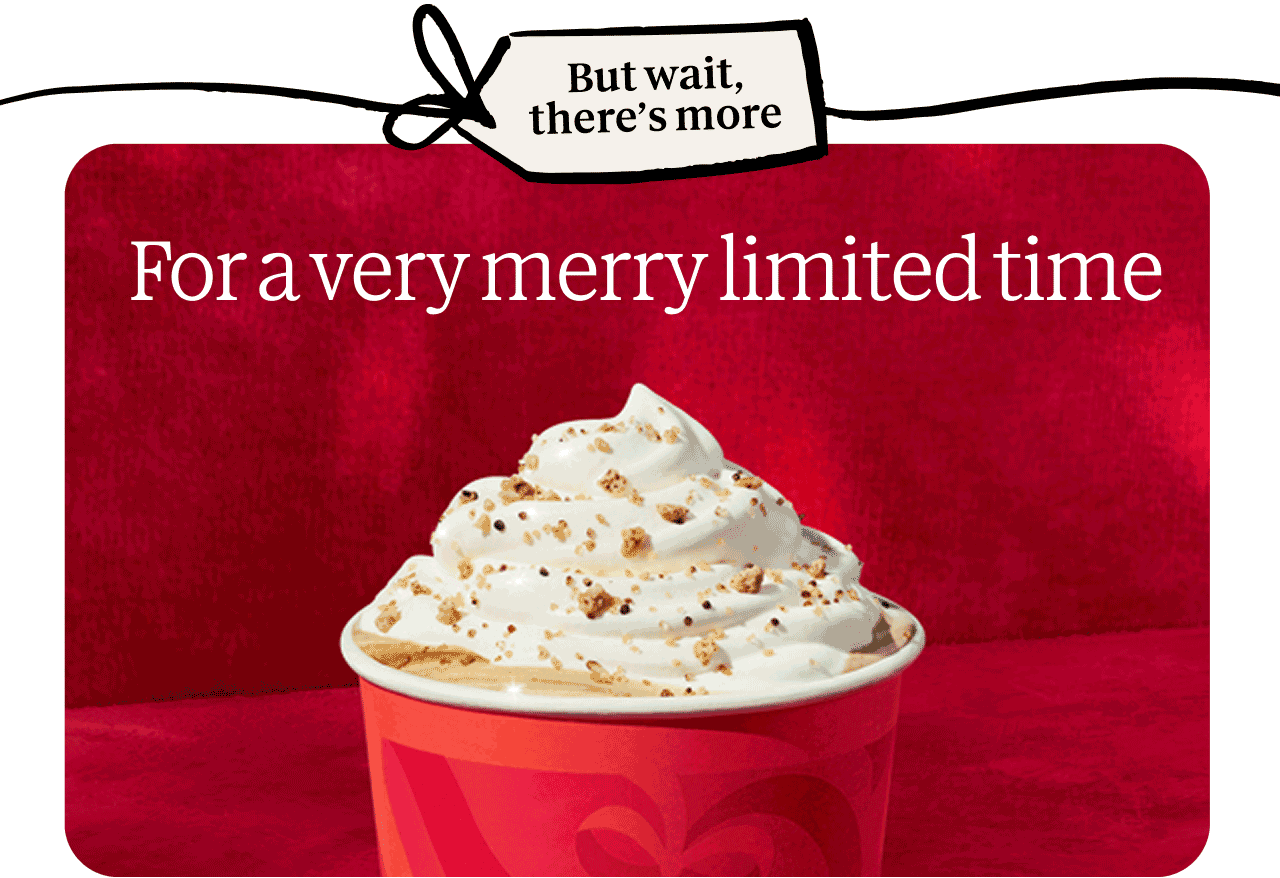But wait, there's more | For a very merry limited time | Close-up of a hot coffee drink in a to-go cup topped with whipped cream and a crunchy topping.