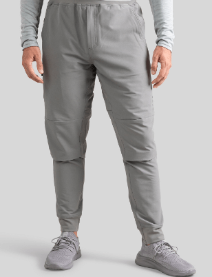 a man wearing grey sweatpants and grey shoes