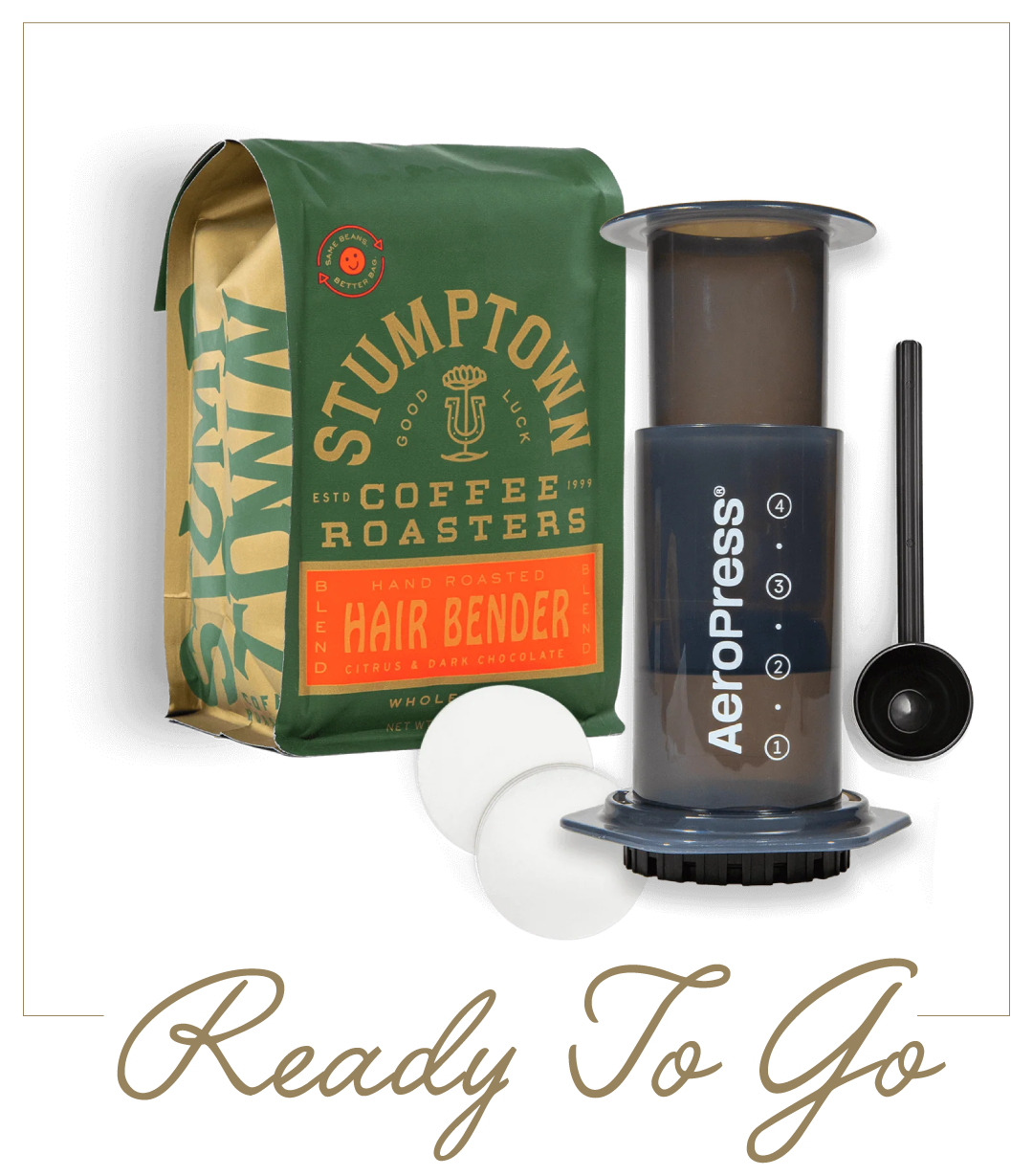 AeroPress and bag of Stumptown Hair Bender coffee with scoop and filters. Text reads “Ready To Go.”