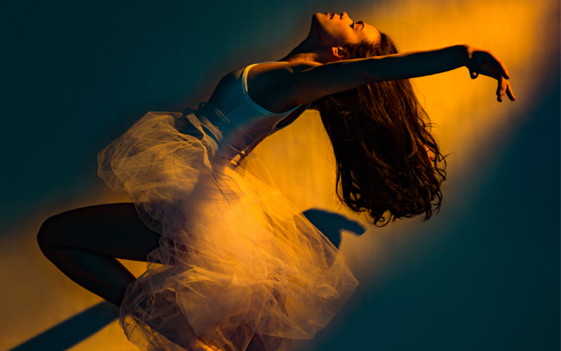 A ballerina dances in front of a blank background