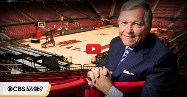Johnny Holliday poses at Xfinity Center, with red play button
