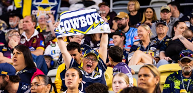 Excited Cowboys fan holding up a sign that says 'Cowboys'.