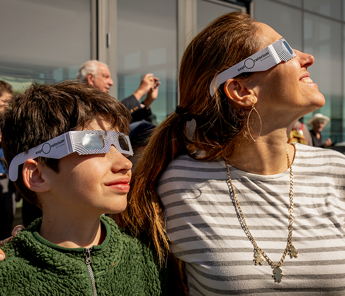 A woman and her son looking at an eclipse.