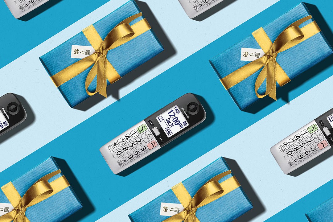 KX-TGU430 Telephone arranged with christmas presents on blue background