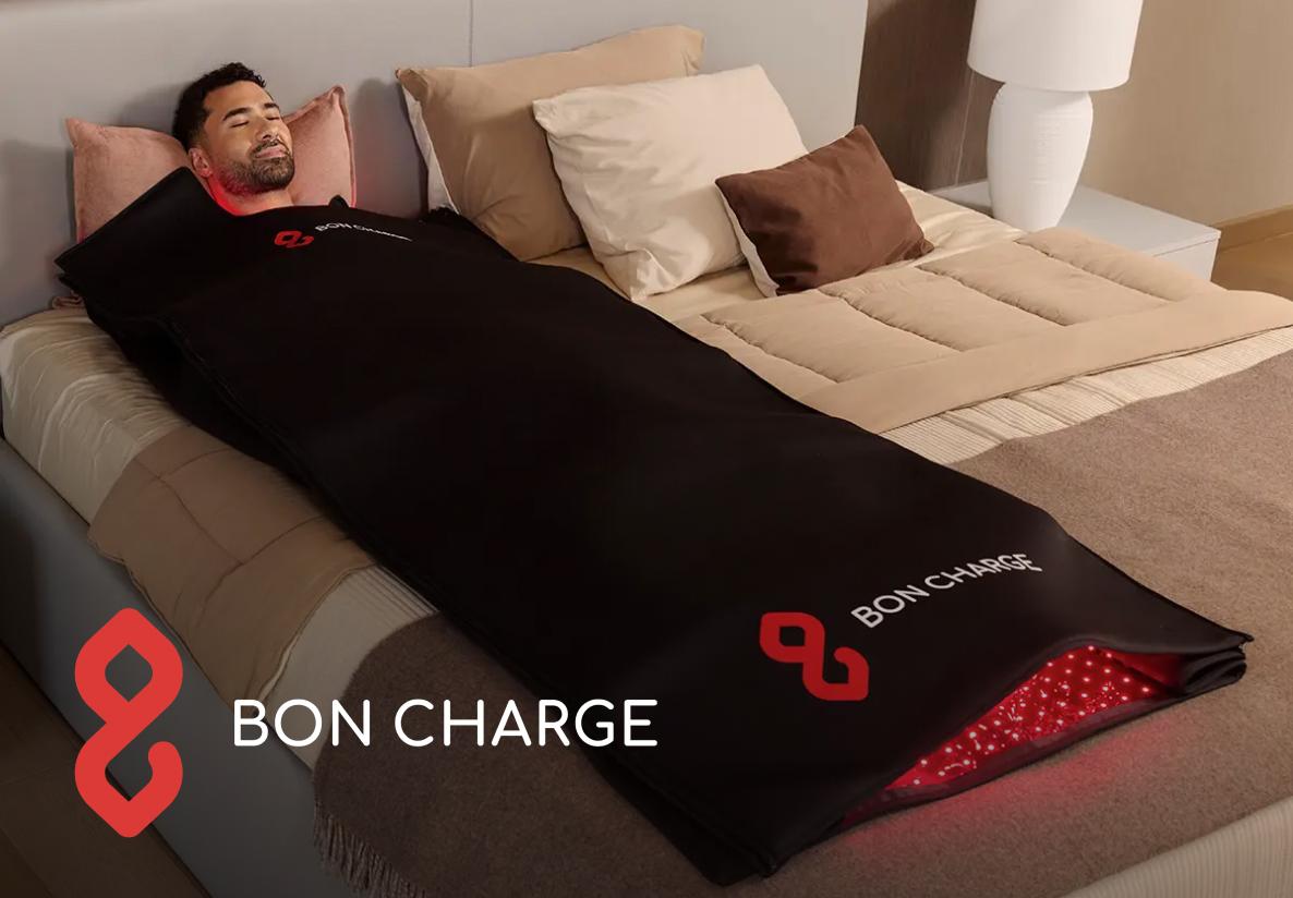 Man lying in a Bon Charge red light therapy device on a bed