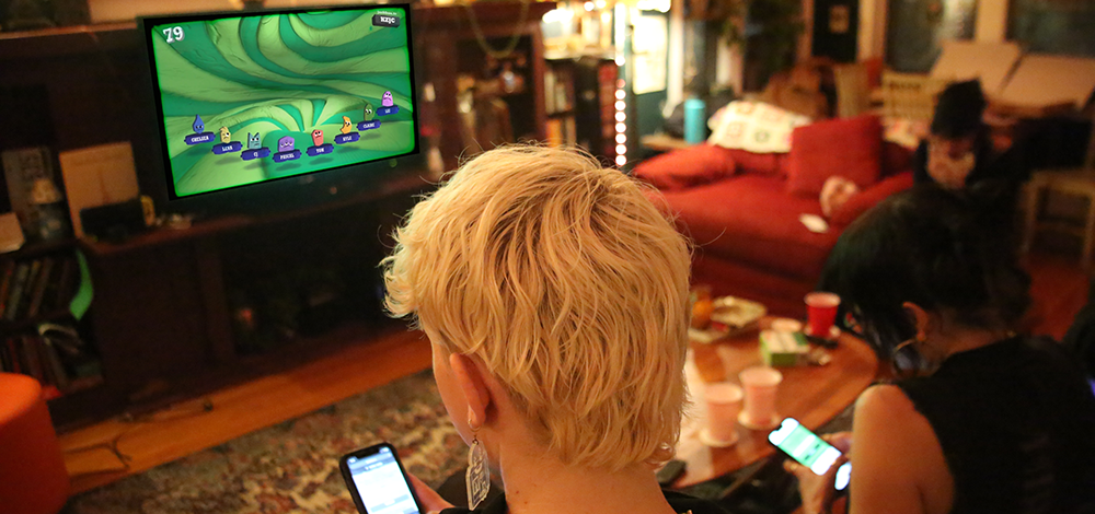 Photo of 3 friends playing Jackbox games on their phones.