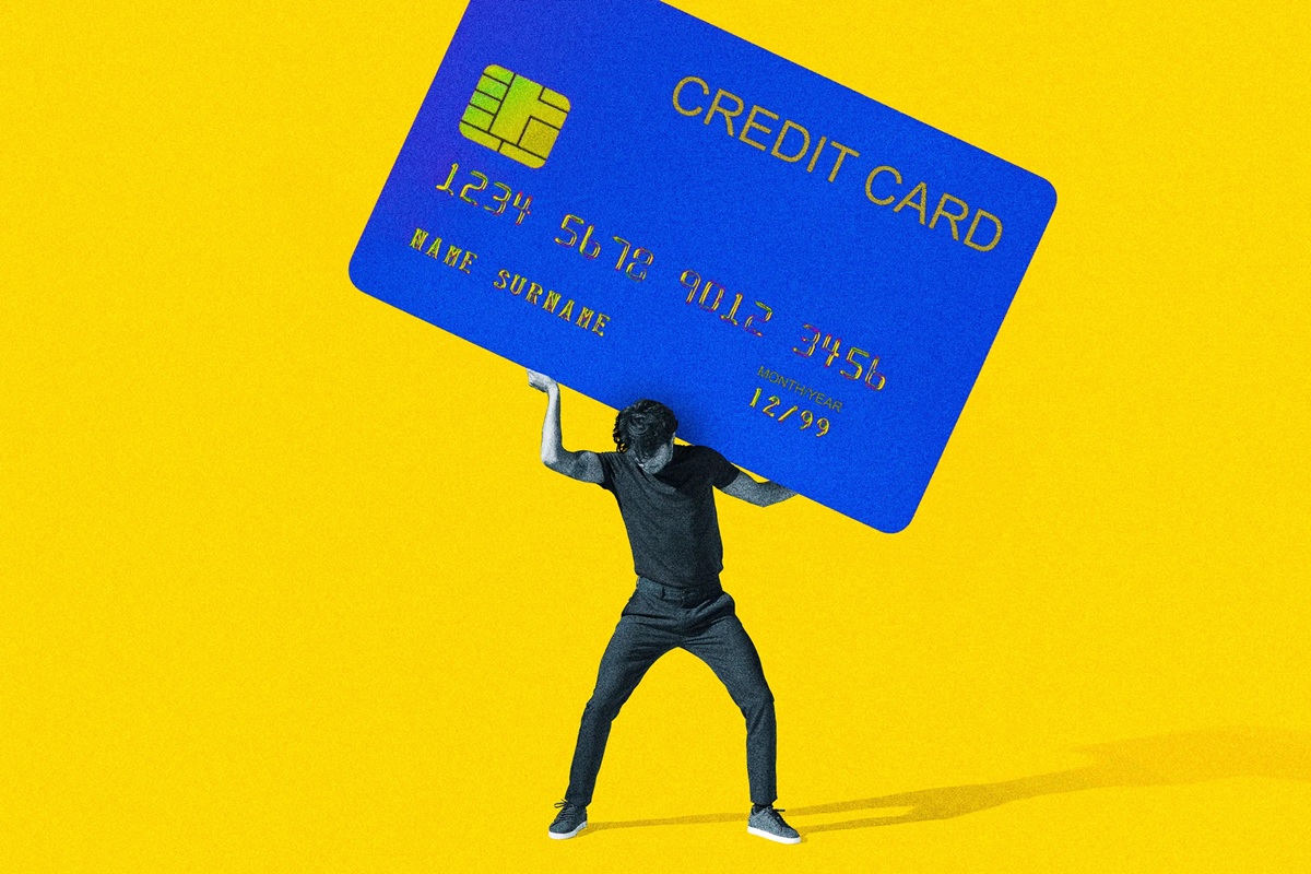 Image of a man holding up a giant credit card over his head