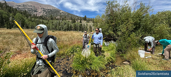 People carry nets and buckets as they walk through a stream, working to monitor cutthroat trout populations