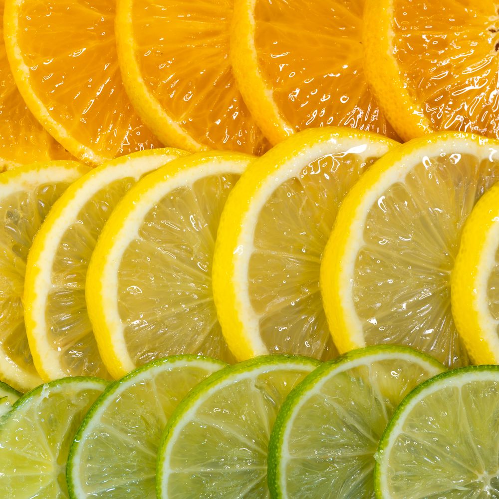 Slices of oranges, lemons, and limes lined up in a gradient. 