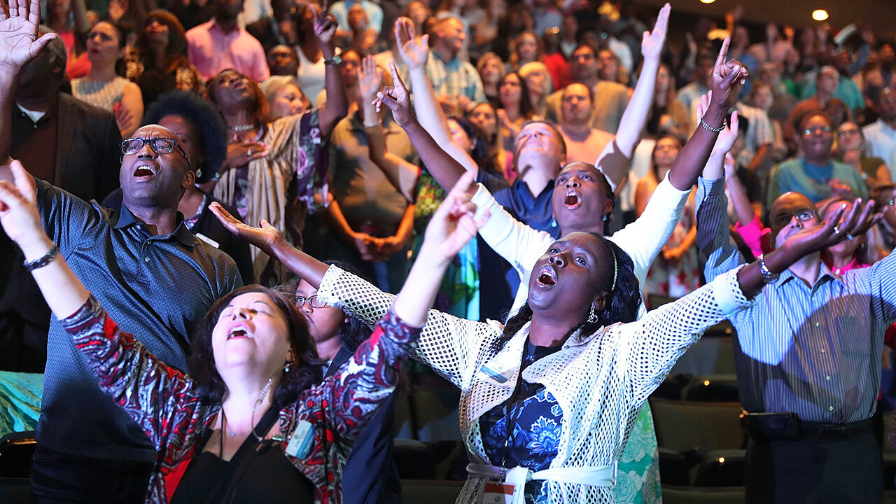 Parishioners of the Lakewood Church led by Pastor Joel Osteen pray together during a service