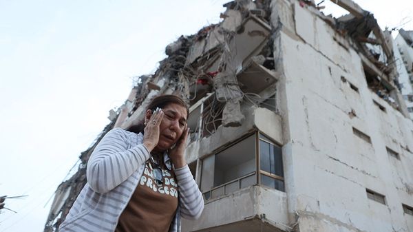 A woman walks past a building damaged during an earthquake in La Guaira, Venezuela, June 25th 2026