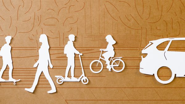 white paper cutouts of people riding skateboard, walking, riding scooter, biking, and a car, on a brown background