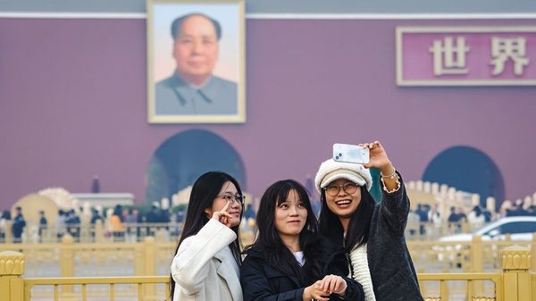 Visitors take selfies in front of the large portrait of late Chinese leader Mao Zedong at Tiananmen Gate, Beijing, China.
