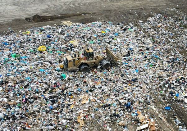 Aerial view of waste and garbage being flattened by heavy machinery