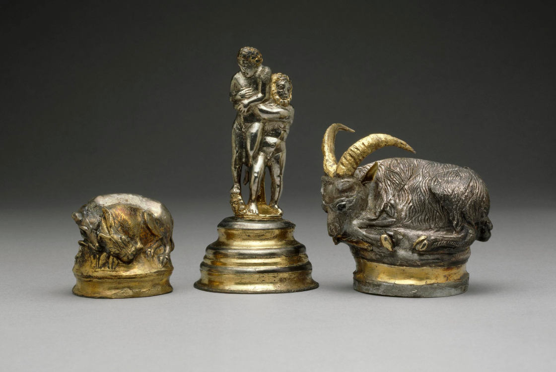 Collection of vessels - left to right, a hound attacking a hare, figures wrestling, and an ibex. 