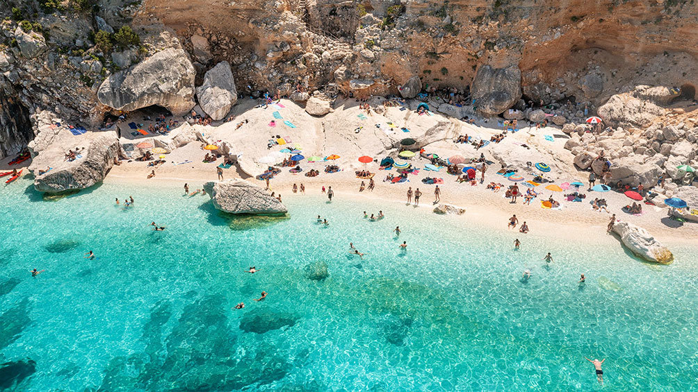 Image description: People swimming at Cala Goloritze, Sardinia.
