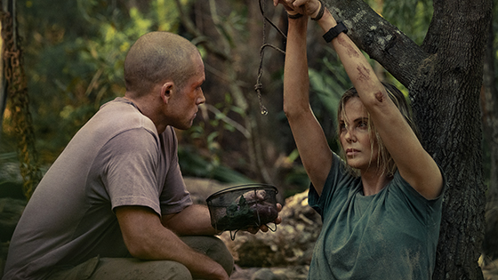 A man and a woman in the woods. The woman is tied up.