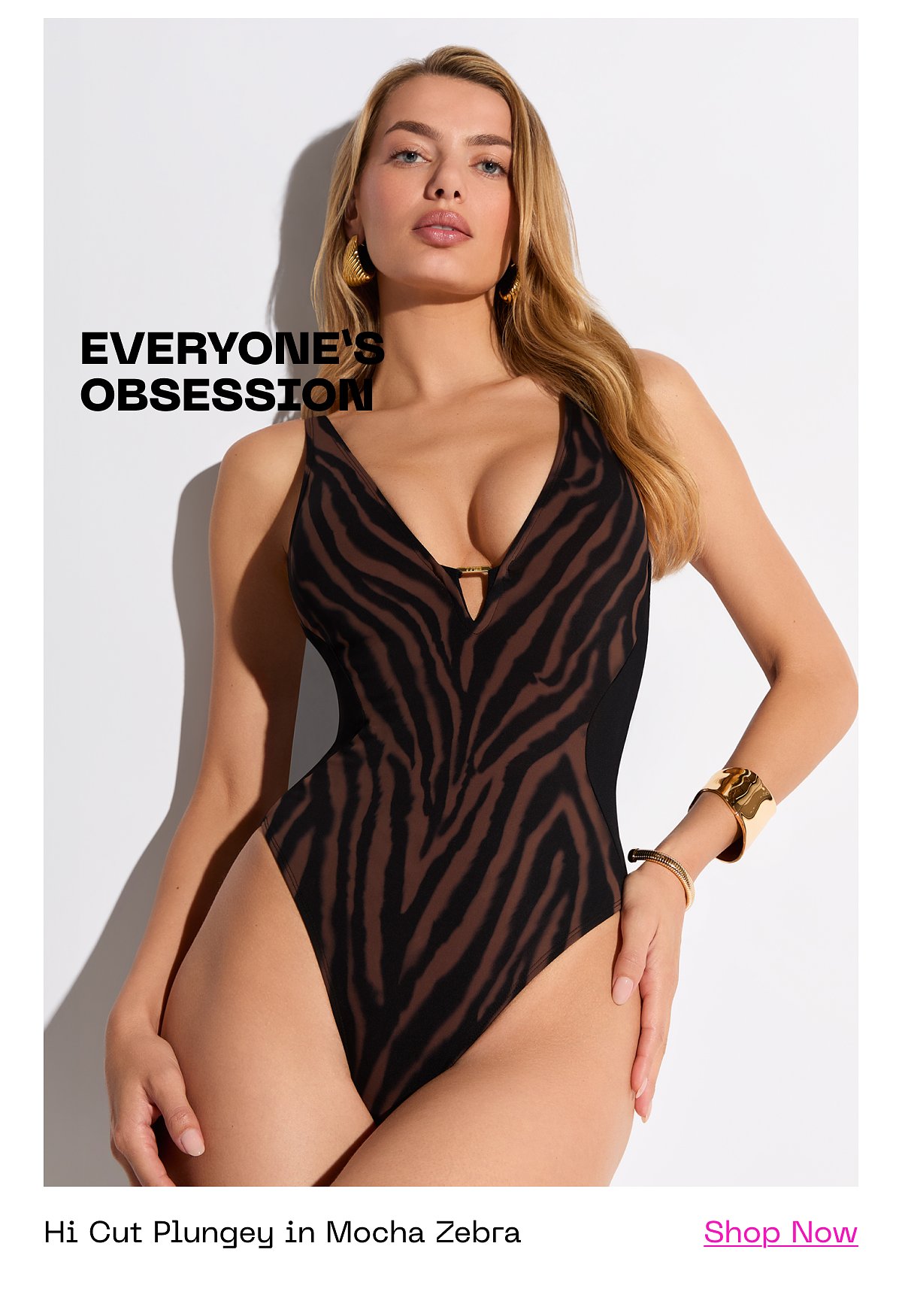 A model wearing a black and brown zebra-striped swimsuit, posing confidently.