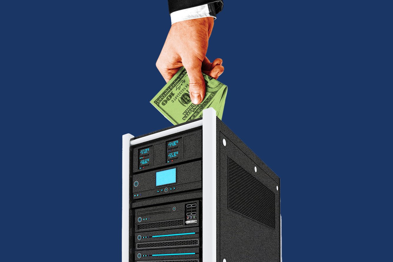 A hand pushing money into a computer