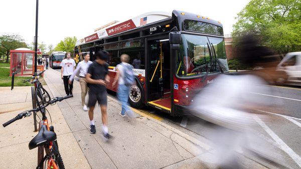 people walk by electric Shuttle-UM bus
