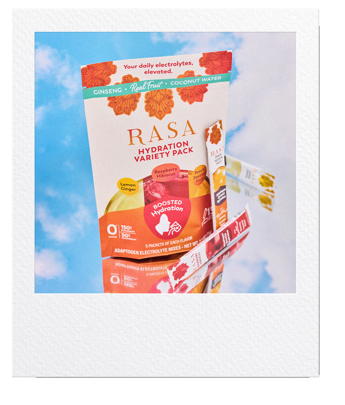 A polaroid picture of the Rasa Hydration Variety pack sitting on a mirror with clouds behind and reflected. 