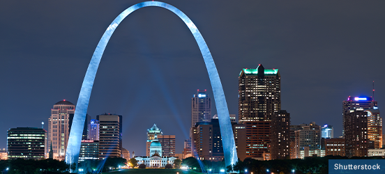 Gateway Arch illuminated at night spanning the skyline of St Louis, Missouri