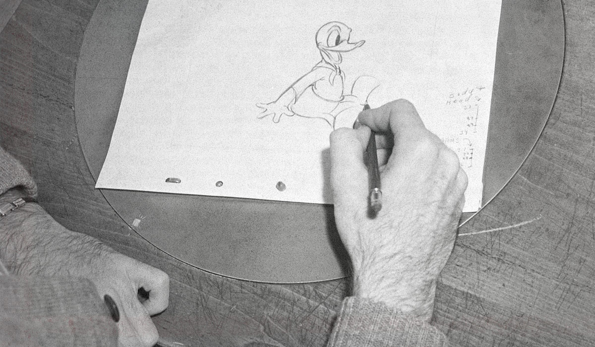 A hand draws Donald Duck.