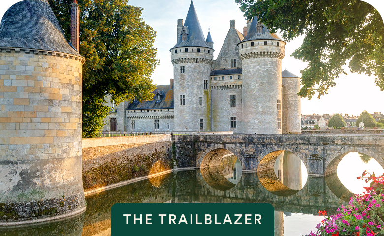 Stone château and moat at golden hour with The Trailblazer badge on Paris, Normandy, Brittany Coast & the Loire Valley — opens itinerary.