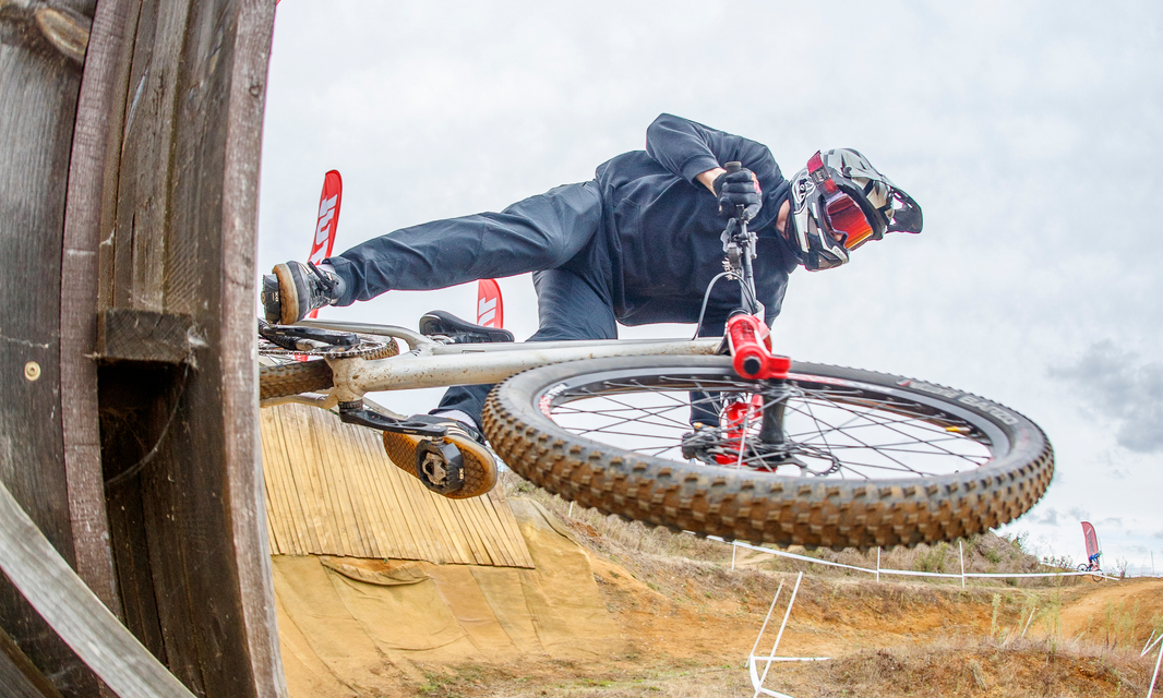 A four cross rider exiting a vertical wall ride section mid-race.