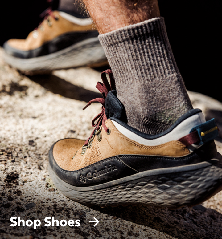 Close-up of a man's brown and black hiking shoes with text: Shop Shoes