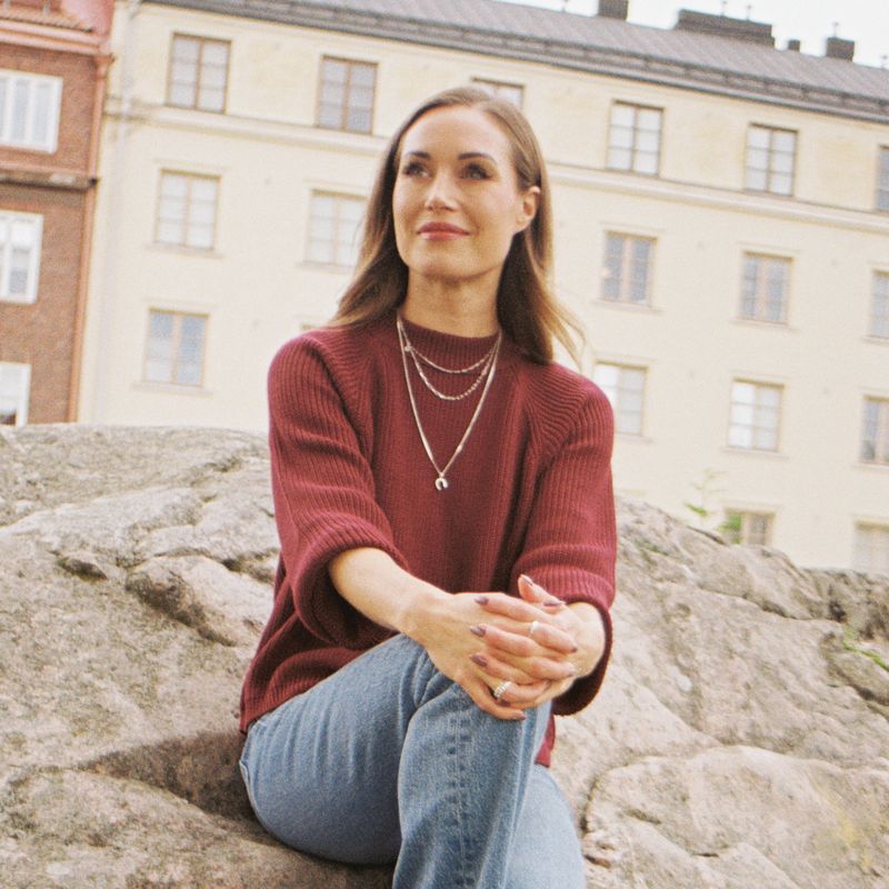 A woman sitting on a rock.