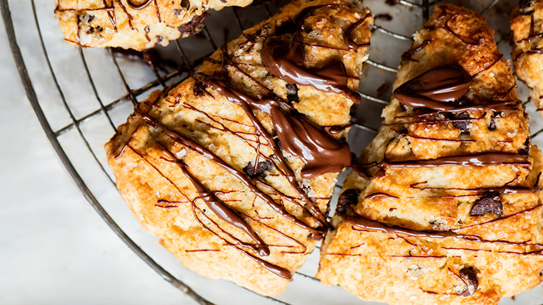 Close-up of chocolate chip scones with chocolate drizzled on top.
