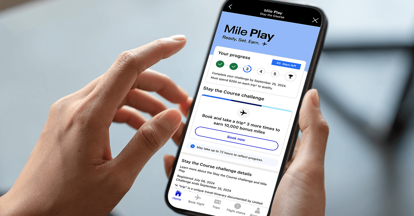 A person holds a smartphone and participates in Mile Play.