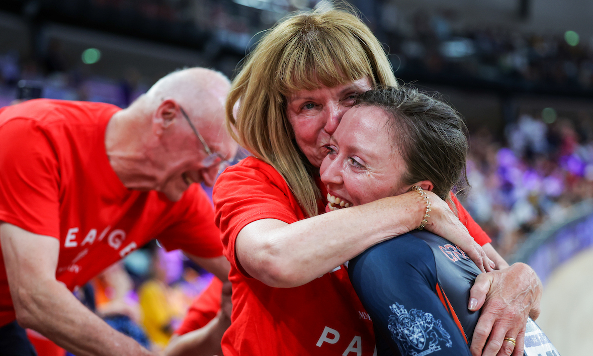 Anna at the side of the Paris 2024 Olympic velodrome being embraced by someone in celebration.