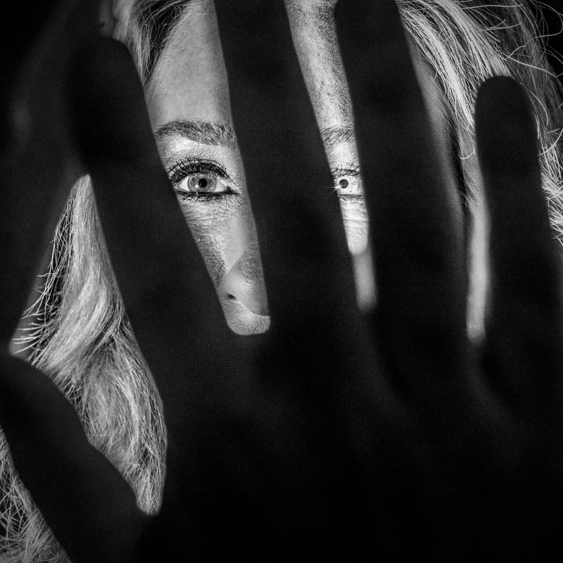 A hand in front of a woman's face