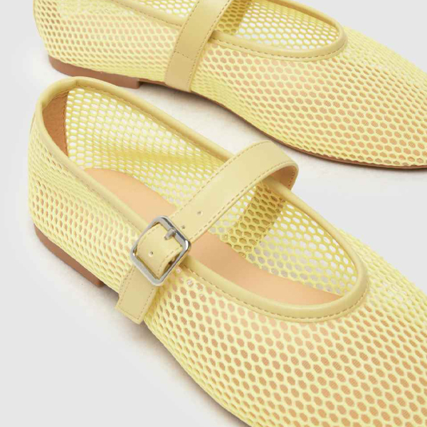 An image of a pair of butter yellow mesh ballerina flats
