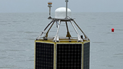 A black and yellow research buoy with a Rutgers insignia floats on the Atlantic off the New Jersey coast.